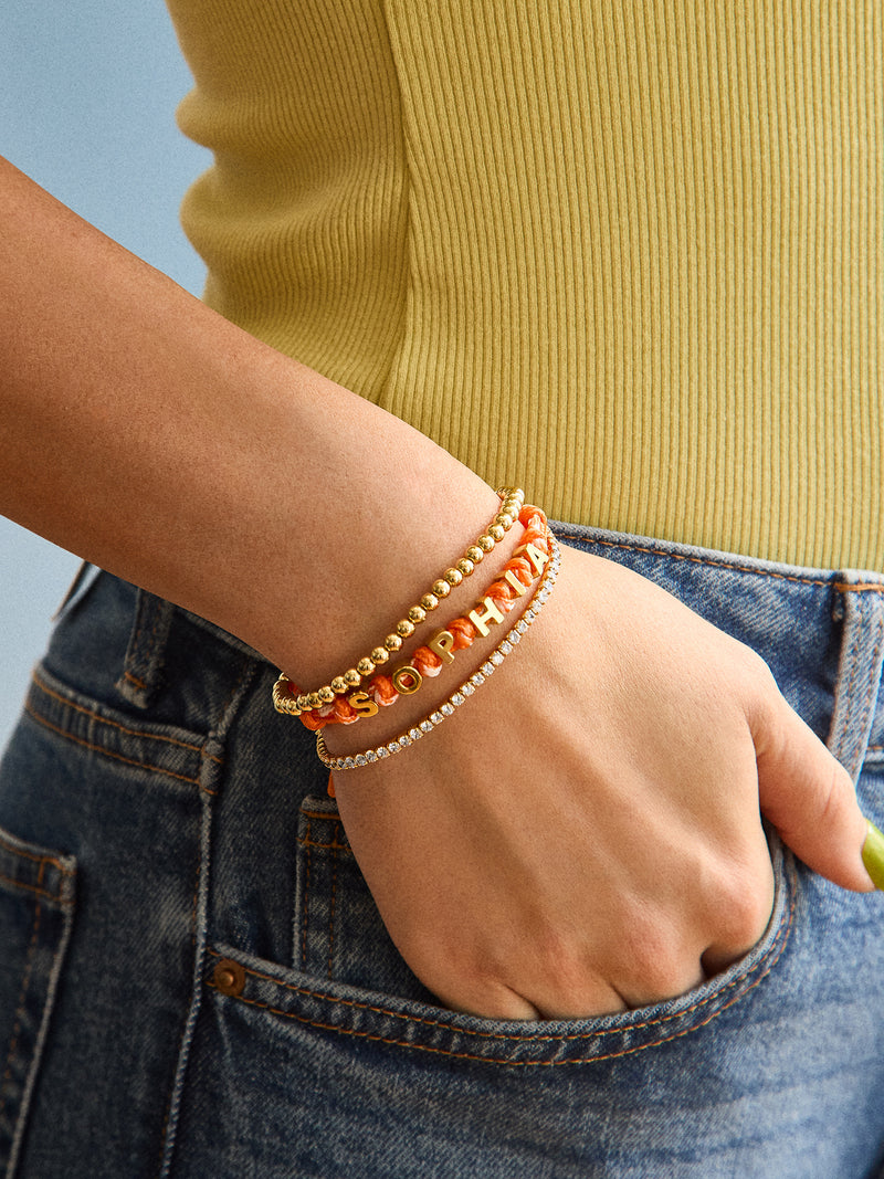 BaubleBar Custom Knotted Nameplate Bracelet - Light Orange/Orange - 
    Customizable bracelet - water resistant
  
