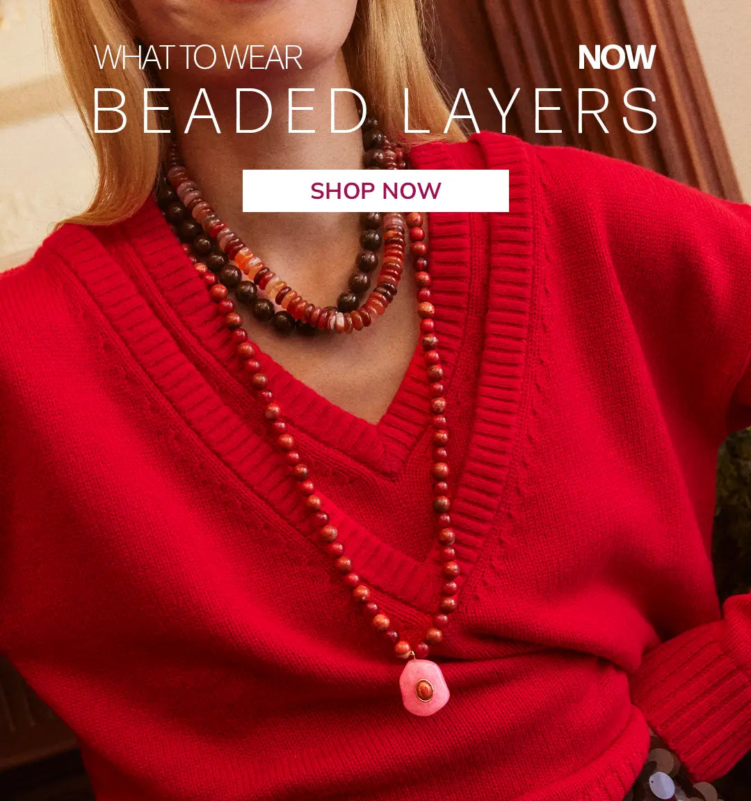 Woman in a red V-neck sweater wears layered red, brown and orange beaded necklaces with a pink stone pendant. Text reads “What to wear now: Beaded Layers.” Button: “Shop Now.”