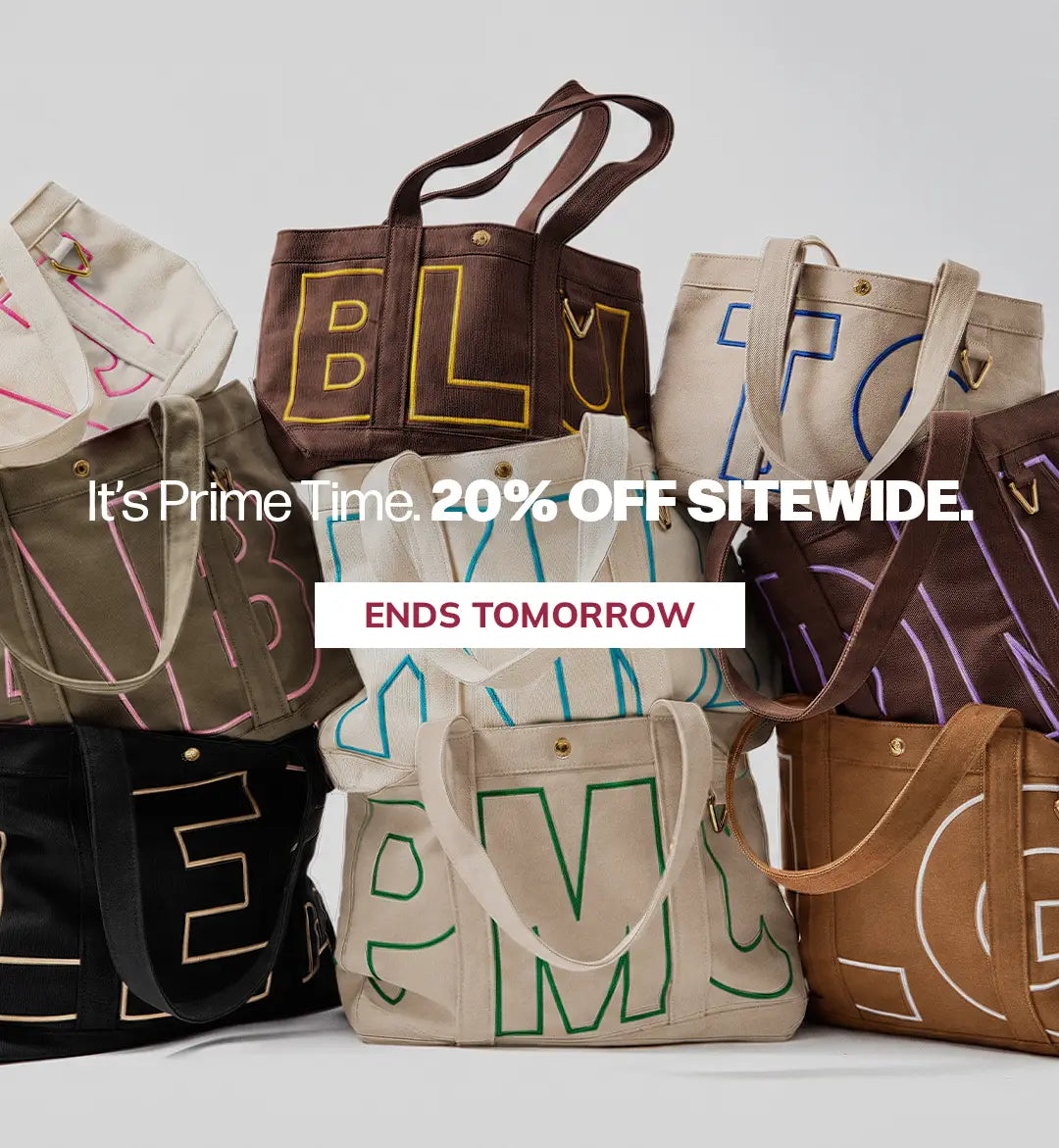 A group of canvas tote bags in multiple colors, each outlined with large decorative lettering, arranged together on a light gray background with promotional text overlay.